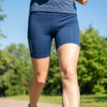 Gros plan sur une coureuse portant un short de sport bleu marine ajusté en extérieur.