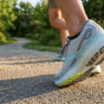 Gros plan sur une chaussure Brooks Ghost 16 portée par un coureur sur un sentier en pleine nature.