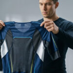 Un homme examine attentivement une trifonction de triathlon dans un magasin de sport.